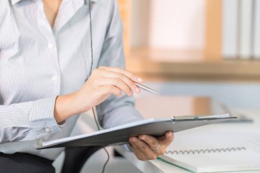 Müşteri bilgilerini inceleyen bir müşteri hizmetleri acentesi telefonda detaylara ve profesyonelliğe dikkat göstermektedir..