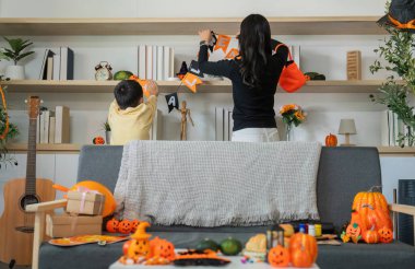 Bir anne ve oğlu Cadılar Bayramı pankartları asarken birbirlerine bağlanıyorlar. Evlerinde şenlikli bir ortam yaratıyorlar..