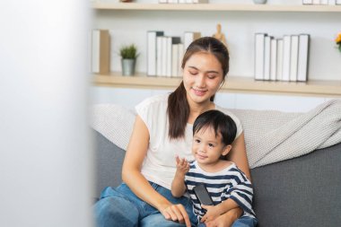 Bir anne ve küçük oğlu dizüstü bilgisayardan bir şey izlerken keyifli bir anı paylaşıyor, sıcak bir ortamda bağ kuruyor ve öğreniyor..