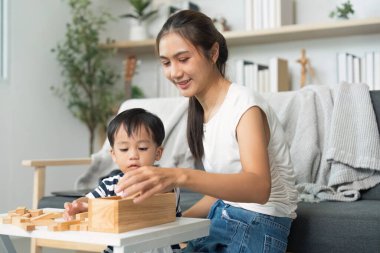 Bir anne ve oğlu, ahşap blokları istiflemek, yaratıcılığı arttırmak ve rahat bir oturma odasında bağ kurmak gibi eğlenceli bir aktiviteye girişiyor..