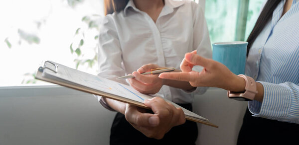 Two women collaborating on performance metrics in a modern office, emphasizing teamwork and effective communication.