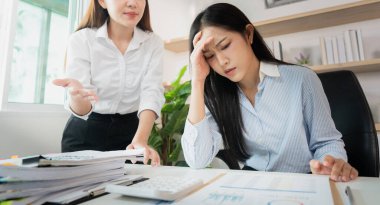 Stresli bir çalışan, menajeri performans sorunlarını modern bir ofiste tartışırken kafasını hayal kırıklığına uğratıyor..