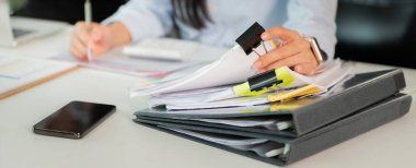 Evrak ve dosyaları düzenleyen, profesyonel bir ortamda organizasyon ve verimliliğin önemini gösteren bir kadın..