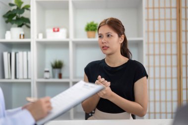 Bir sağlık hizmetleri uzmanı hasta bilgilerini hasta bakımının önemini vurgulayarak bir sohbete katılırken belgelemektedir..