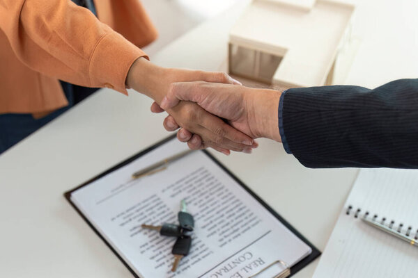 A close-up of a handshake between a client and a real estate agent, symbolizing the successful completion of a property deal.