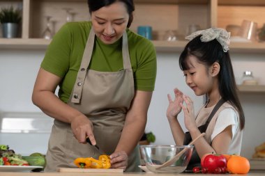 Bir anne kızına dolmalık biber dilimlemeyi, aile bağlarını geliştirmeyi ve sıcak bir mutfakta sağlıklı yemek pişirmeyi öğretir..