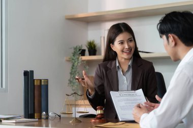 Avukat, sözleşmenin detaylarını müşteriye hevesle açıklar ve olumlu ve bilgilendirici bir yasal danışmanlık sağlar..