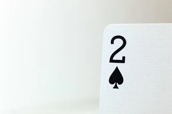 Maça ikilisinin üst köşesindeki soluk arkaplanda kağıt oynayan makro fotoğraf.