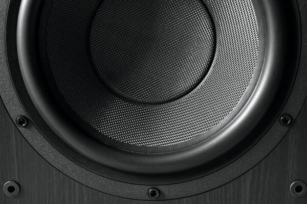 Close up photo of a sub-woofer speaker showing the texture of the speaker membrane and the bolts that hold it in place.