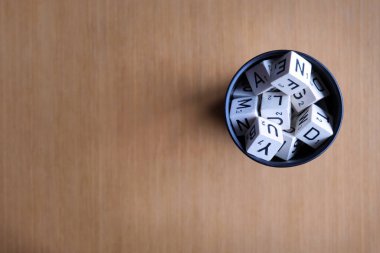 Bir grup kelime zarı siyah bir karıştırıcı bardağın içinde rastgele dizilmiş.