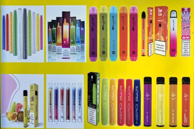 Bradford, UK 11 10 2023 : Close Up of a mixture of vibrantly vcoloured disposal electronic cigarette vapes being advertised on the exterior of a convienience store. clipart