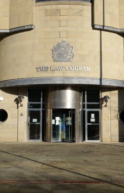 Bradford, UK 11: 30 2023: Bradford şehir merkezindeki hukuk mahkemelerinin dış ve döner kapı girişi, parlak güneş ışığı binanın üzerine uzun gölgeler düşürüyor