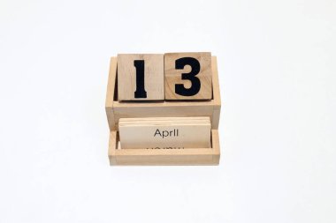 13 Nisan 'ı gösteren daimi ahşap takvimi kapat. Yakın çekim, beyaz bir arkaplanda izole edilmiş.