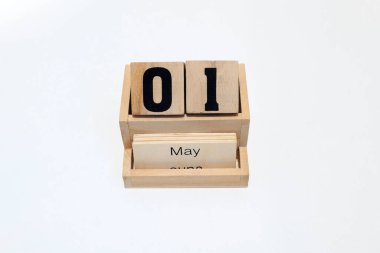 1 Mayıs 'ı gösteren daimi ahşap takvimin kapağını kapatın. Yakın çekim, beyaz bir arkaplanda izole edilmiş.