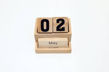2 Mayıs 'ı gösteren daimi ahşap takvimin kapağını kapatın. Yakın çekim, beyaz bir arkaplanda izole edilmiş.