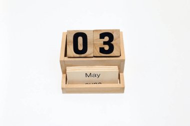 3 Mayıs 'ı gösteren daimi ahşap takvimin kapağını kapatın. Yakın çekim, beyaz bir arkaplanda izole edilmiş.