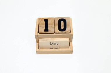 10 Mayıs 'ı gösteren daimi ahşap takvimin kapağını kapatın. Yakın çekim, beyaz bir arkaplanda izole edilmiş.