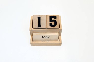 15 Mayıs 'ı gösteren ahşap daimi takvimi kapat. Yakın çekim, beyaz bir arkaplanda izole edilmiş.