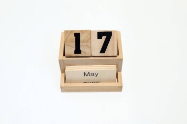 17 Mayıs 'ı gösteren ahşap daimi takvimin kapağını kapatın. Yakın çekim, beyaz bir arkaplanda izole edilmiş.