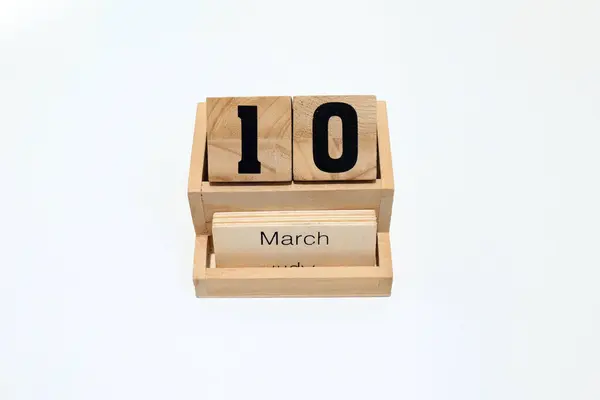 10 Mart 'ı gösteren daimi ahşap takvimi kapat. Yakın çekim, beyaz bir arkaplanda izole edilmiş.
