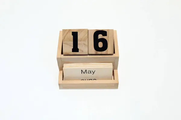 16 Mayıs 'ı gösteren ahşap daimi takvimin kapağını kapatın. Yakın çekim, beyaz bir arkaplanda izole edilmiş.