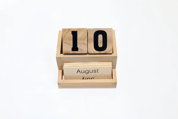 Ağustosun 10 'unu gösteren daimi ahşap takvime yakın çekim. Yakın çekim, beyaz bir arkaplanda izole edilmiş.