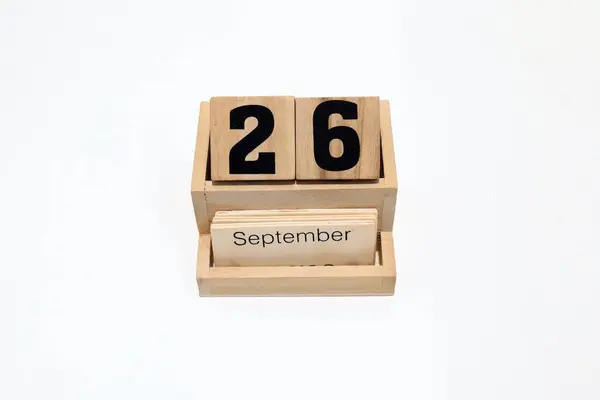 26 Eylül 'ü gösteren ahşap daimi takvimi kapat. Yakın çekim, beyaz bir arkaplanda izole edilmiş.
