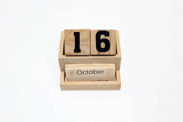 16 Ekim 'i gösteren ahşap daimi takvimi kapat. Yakın çekim, beyaz bir arkaplanda izole edilmiş. 