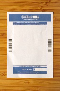 Bradford, UK 05 04 2024 Blank William Hill betting slip shot over a pale wooden background clipart