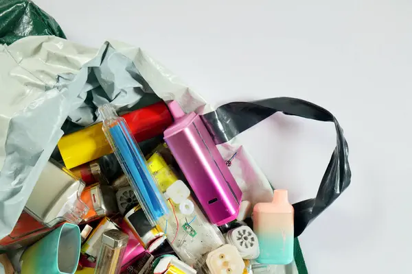 İçinde parçalanmış ve kırılmış elektronik sigara izmaritleri olan plastik bir poşet açılır. Fotokopi alanı olan beyaz kağıt bir arkaplanda çekildi