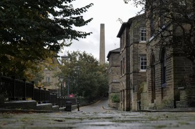 Saltaire, UK 10 08 2024 Victorian cobbled terrace in autumn with mill houses and chimney seen. Part of the wider unesco world heritage site of Saltaire clipart