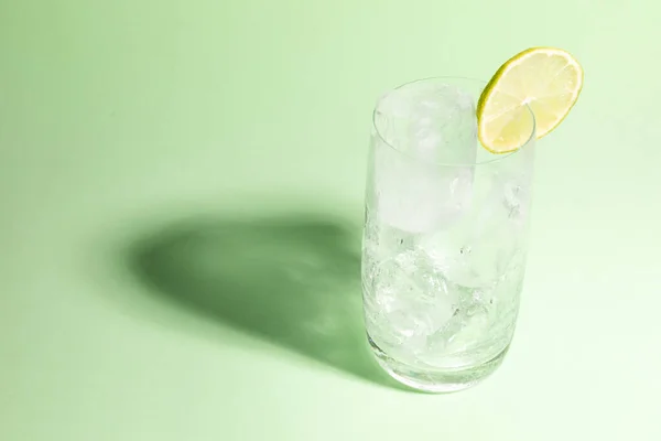 Kaltes Glas Voller Eis Mit Einer Limettenscheibe Auf Grün — Stockfoto