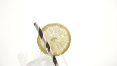 Buz küplü taze cam ve beyaz üzerine limon ve çizgili siyah beyaz pipet.