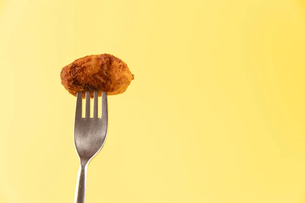 Sarı zemin üzerinde bir çatal üzerinde kroket izole