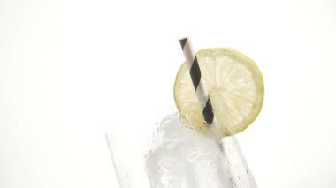 Buz küplü taze cam ve beyaz üzerine limon ve çizgili siyah beyaz pipet.