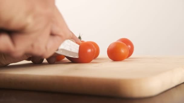 Zwarte Mannelijke Snijden Cherry Tomaten Hout Boord Witte Achtergrond — Stockvideo