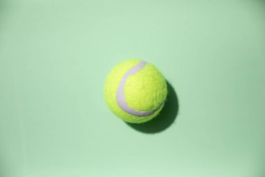 Açık yeşil arka planda, zıt gölgeli tenis topu