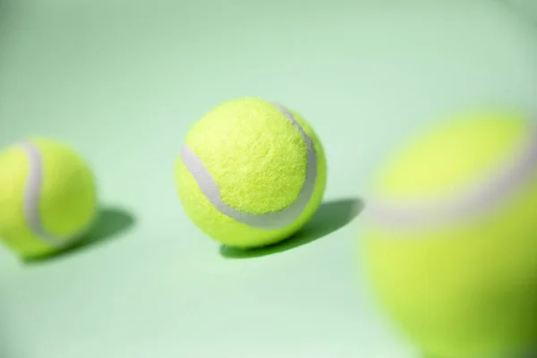 Açık yeşil arka planda, zıt gölgeli 3 tenis topu