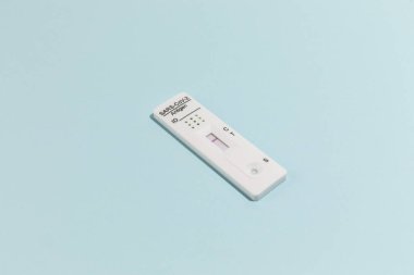 Mavi üzerinde Covid-19 için hızlı test kiti aygıtının resmini kapat