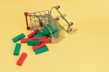 Sarı arka planda alışveriş arabasından düşen Japon mumları. borsa.