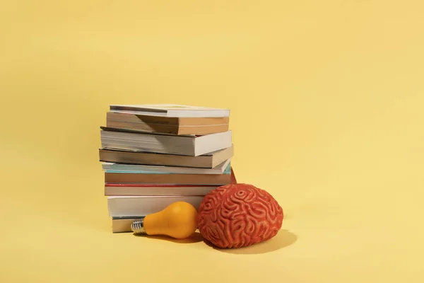 Cerebro Una Bombilla Libros Sobre Fondo Amarillo — Foto de Stock