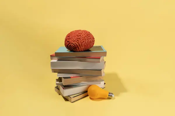Cerebro Una Bombilla Libros Sobre Fondo Amarillo Concepto Creativo Ideas —  Fotos de Stock