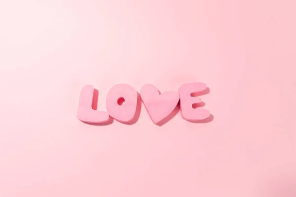 Word LOVE made of pink bubble letters and a heart on pink