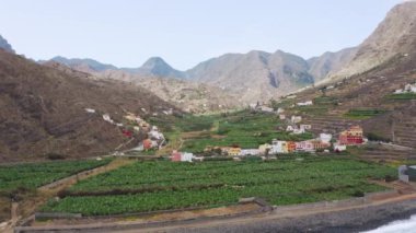 Hava aracı yeşil vadideki küçük kasaba ve çiftlikleri gösteriyor.