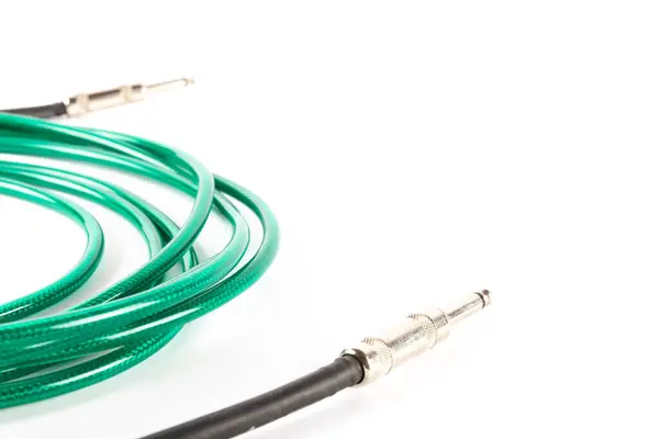 Beyaz arka planda izole edilmiş yeşil gitar kablosu, kopyalama alanı, müzik üretimi. Yüksek kalite fotoğraf