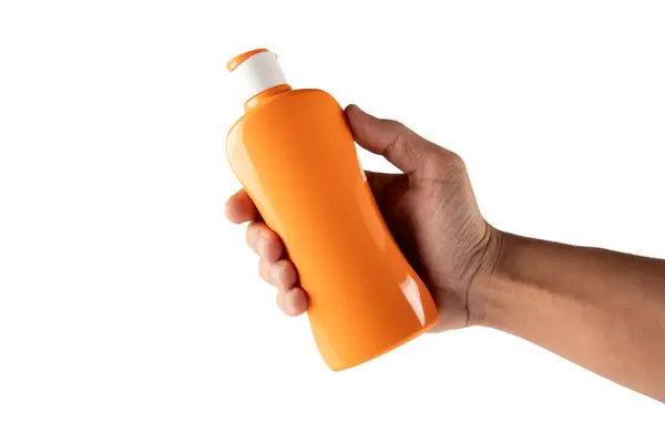 Beyaz arka planda izole edilmiş turuncu bir güneş kremi tutan erkek el. Yüksek kalite fotoğraf