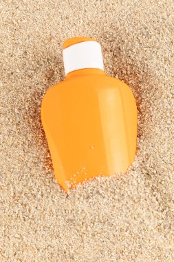 Cyan ve turuncu güneş gözlüğü şişeleri kumsal arka planında. Yüksek kalite fotoğraf