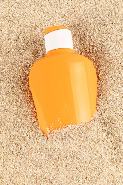 Cyan ve turuncu güneş gözlüğü şişeleri kumsal arka planında. Yüksek kalite fotoğraf