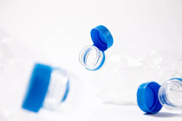 Beyaz arka planda geri dönüşüm için güvenli kapak eklentisi olan plastik şişeler. Yüksek kalite fotoğraf