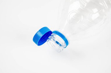 Plastik şişe, beyaz arka planda geri dönüşüm için güvenli kapak eklentisini kapatıyor. Yüksek kalite fotoğraf